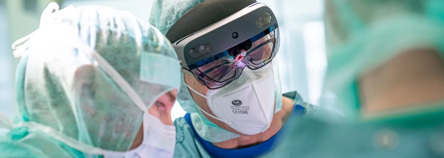 Ärzte während einer Operation, einer von ihnen trägt eine VR-Brille Ärzte während einer Operation, einer von ihnen trägt eine VR-Brille